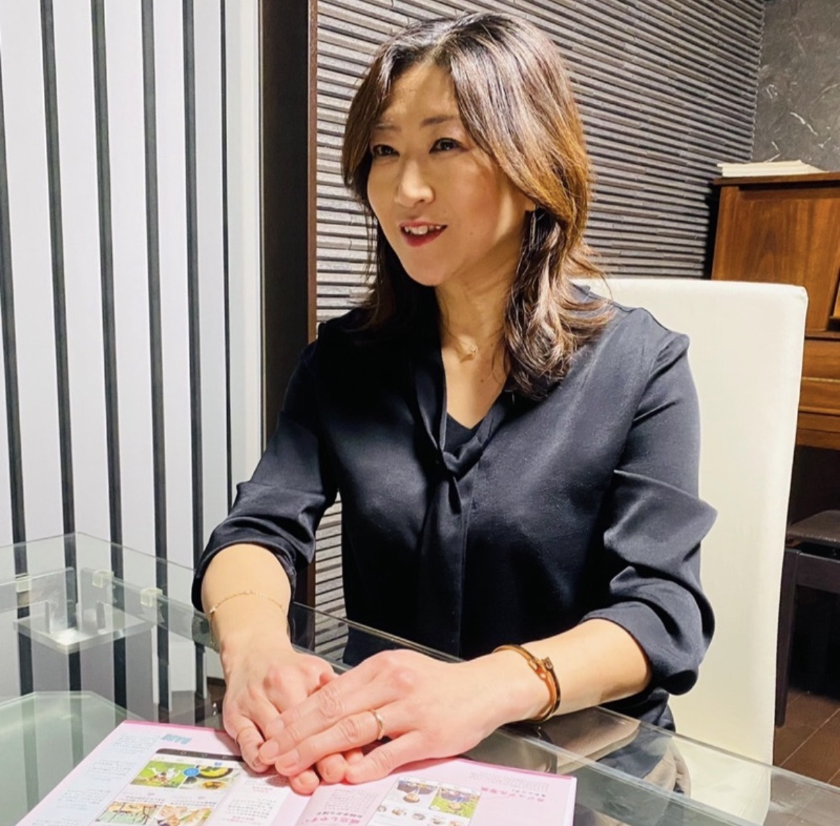 テーブルに資料を広げて話す女性